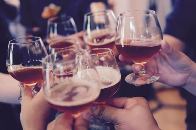 Alcholic Beverages in Glasses with Hands Toasting